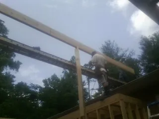 Carpenter setting a ridge beam over a new addition frame — Ice Dam Removal by Roofing Brothers in Linden