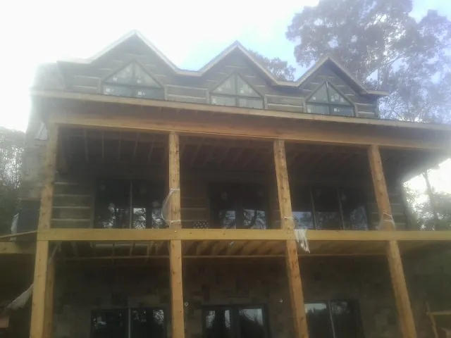 Dormers and porch framing on a large log home under construction in Linden
